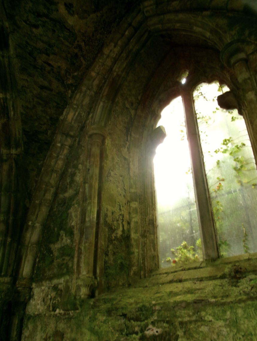 Sunlight through an arched stone window in old ruins